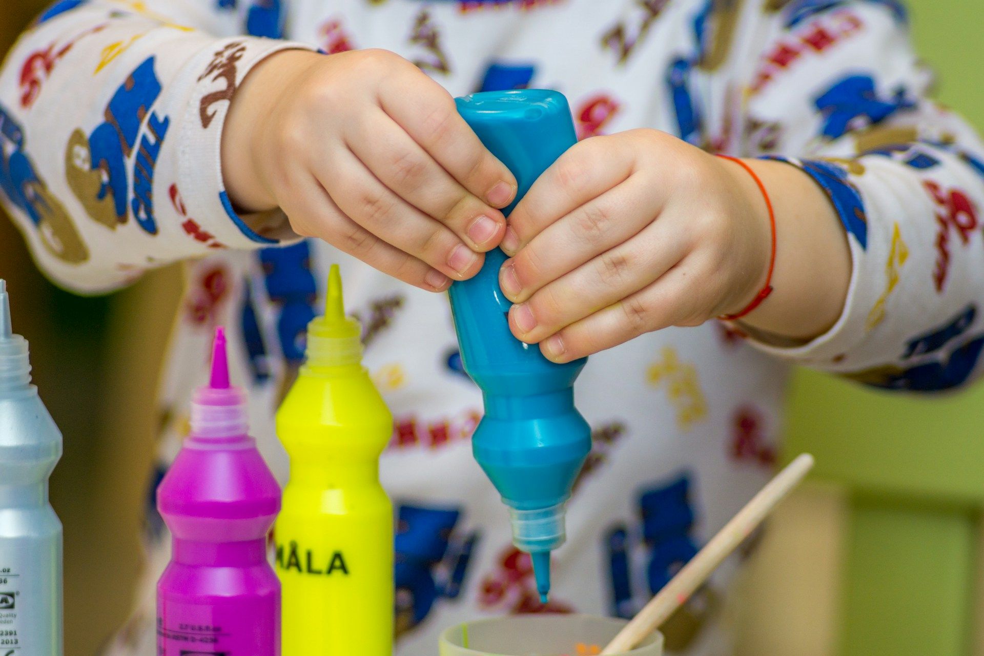 child using paint bottles