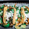 steak and chicken tacos with onion, cilantro, and lime